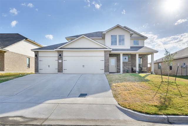 2816 Brosnan Rd, Waco, TX 76655 - view of front of property featuring a front lawn, brick siding, an attached garage, driveway, and covered porch