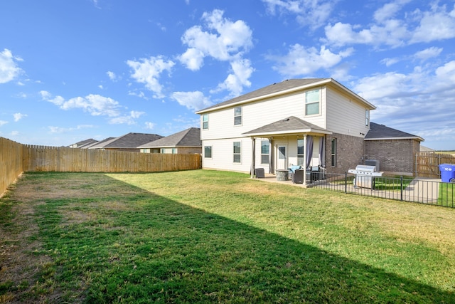 rear view of property with a yard and a patio