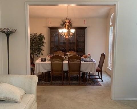 dining room with an inviting chandelier and carpet flooring