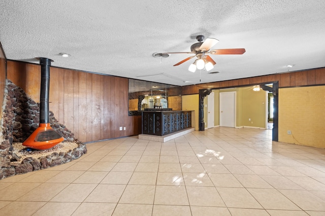 unfurnished living room featuring wooden walls and a textured ceiling