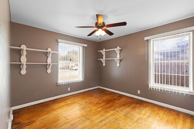 empty room with hardwood / wood-style floors and ceiling fan