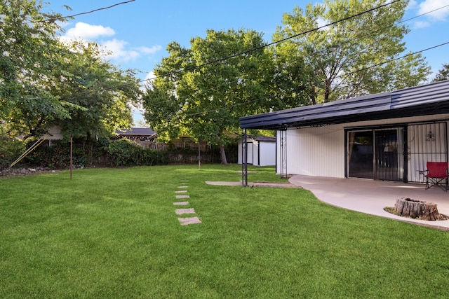 view of yard with a storage unit and a patio