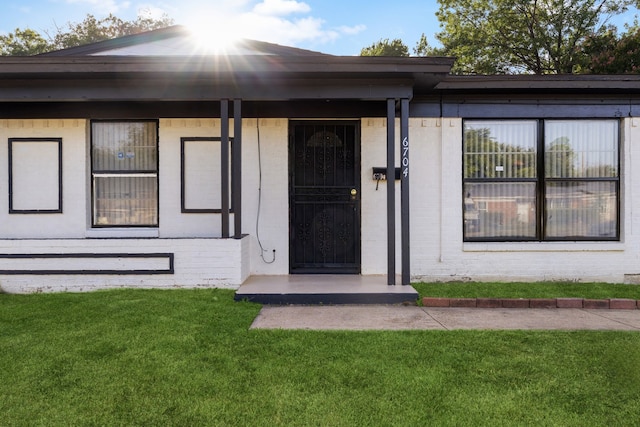 view of exterior entry with a yard