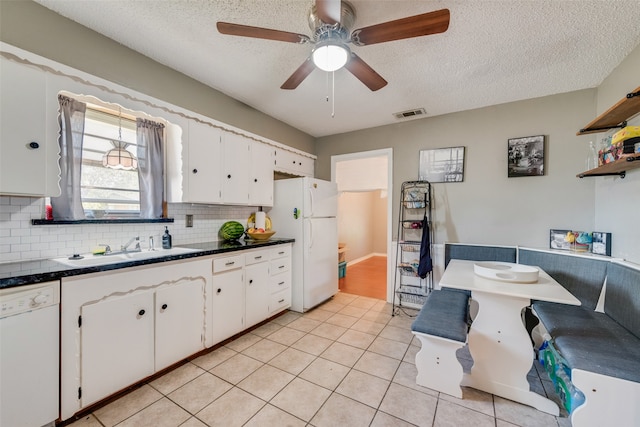 kitchen with white cabinetry, white appliances, sink, and light tile patterned flooring