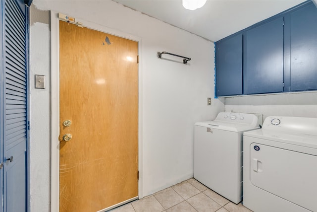 washroom with cabinets, washing machine and dryer, and light tile patterned floors