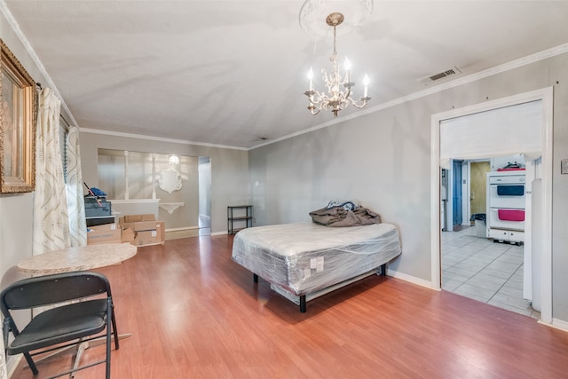 bedroom featuring ornamental molding, hardwood / wood-style floors, and a chandelier