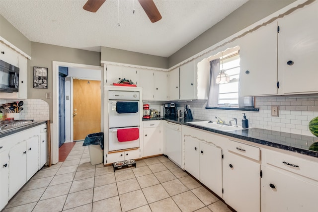 kitchen featuring white cabinets, white appliances, light tile patterned floors, and decorative backsplash