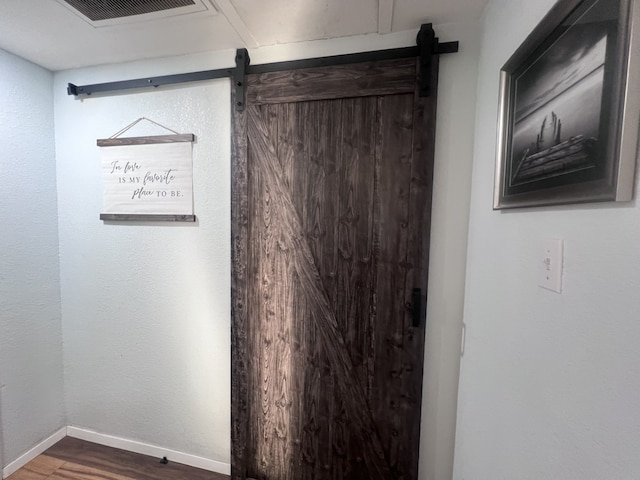 interior details with hardwood / wood-style flooring and a barn door