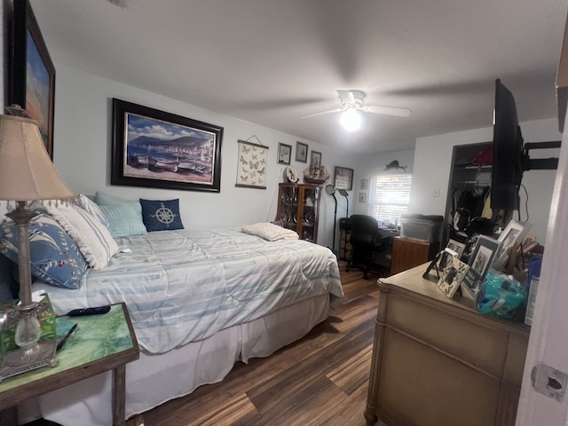 bedroom with dark wood-type flooring, ceiling fan, and a closet