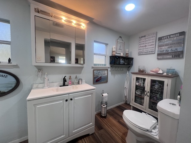 bathroom with hardwood / wood-style flooring, vanity, and toilet