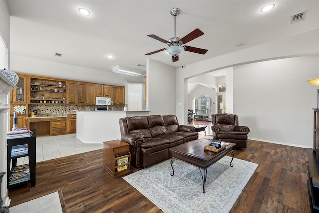 living room featuring light hardwood / wood-style flooring, ceiling fan, and lofted ceiling