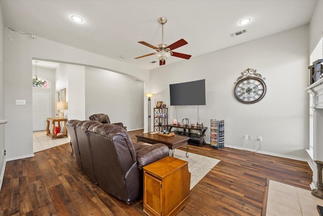 living room featuring dark wood-type flooring and ceiling fan