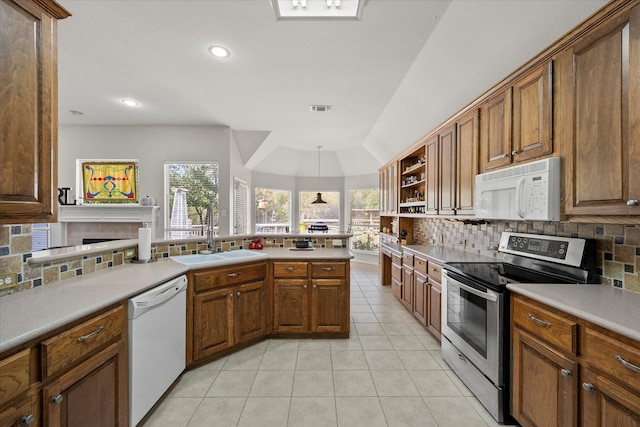 kitchen featuring decorative backsplash, sink, light tile patterned floors, and white appliances