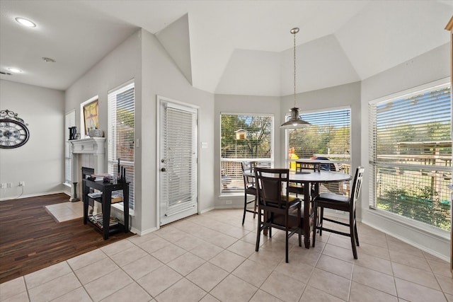 dining room featuring light wood-type flooring, vaulted ceiling, and a wealth of natural light