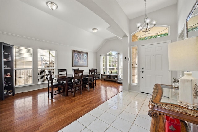 tiled entryway featuring a chandelier and vaulted ceiling