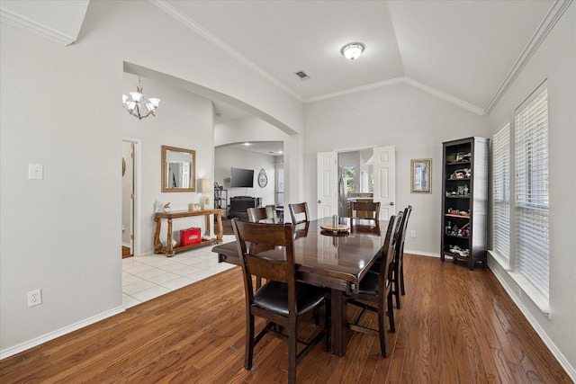 dining room featuring ornamental molding, lofted ceiling, a healthy amount of sunlight, and light hardwood / wood-style floors