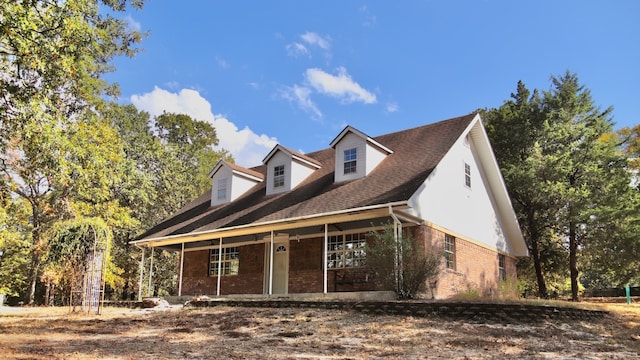 cape cod home featuring a porch