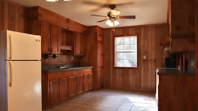 kitchen featuring a textured ceiling, white fridge, and sink