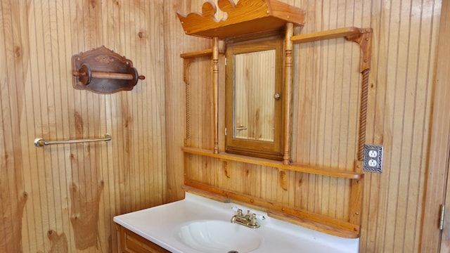 bathroom featuring vanity and wood walls