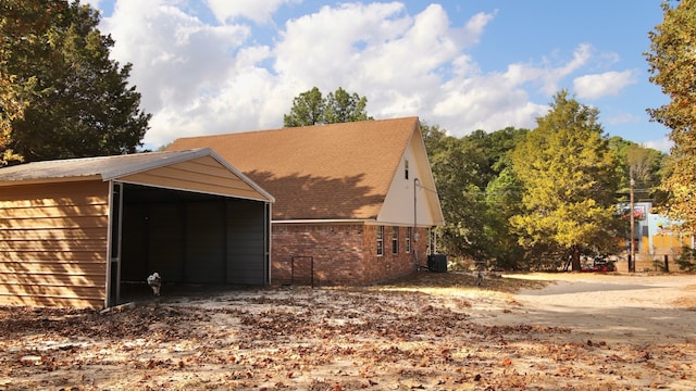 view of outbuilding featuring central air condition unit and a carport