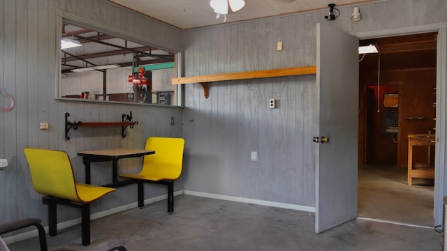 interior space with concrete flooring and wooden walls