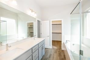 bathroom featuring wood-type flooring, vanity, and shower with separate bathtub