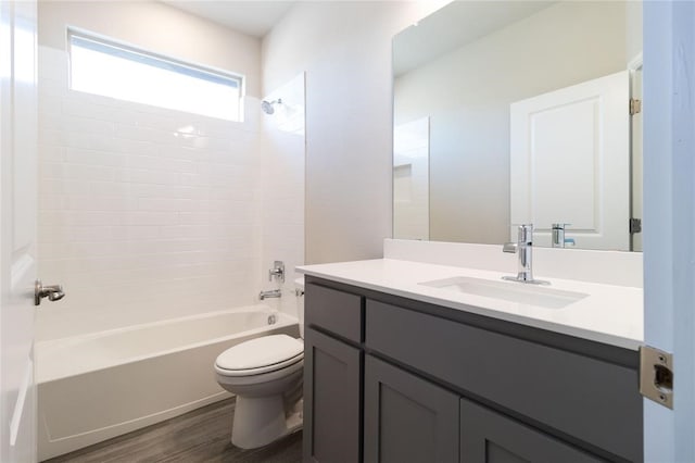 full bathroom featuring vanity, hardwood / wood-style flooring, tiled shower / bath, and toilet