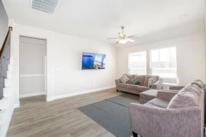 living room with hardwood / wood-style flooring and ceiling fan