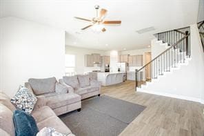 living room with ceiling fan and light wood-type flooring