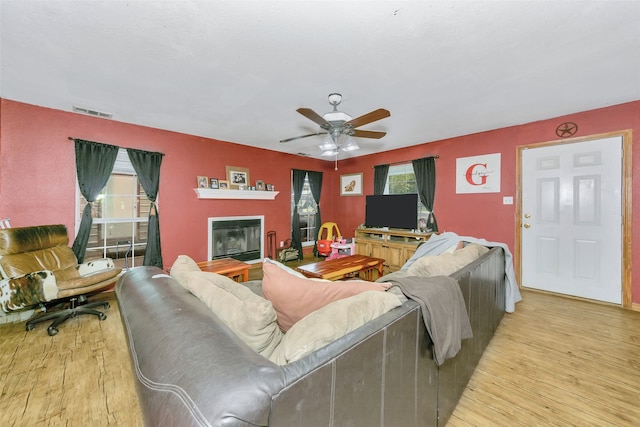 living room featuring light hardwood / wood-style flooring and ceiling fan