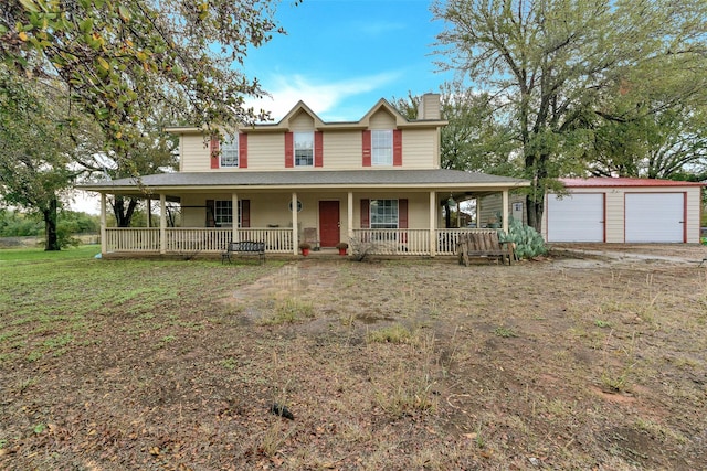 farmhouse-style home with covered porch, a garage, an outbuilding, and a front yard