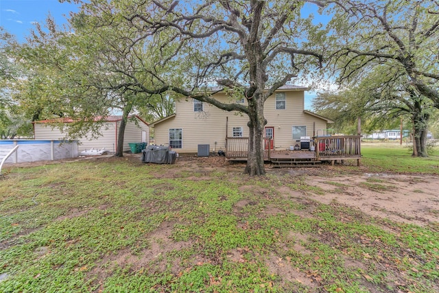 back of property featuring a lawn, a pool side deck, and central air condition unit