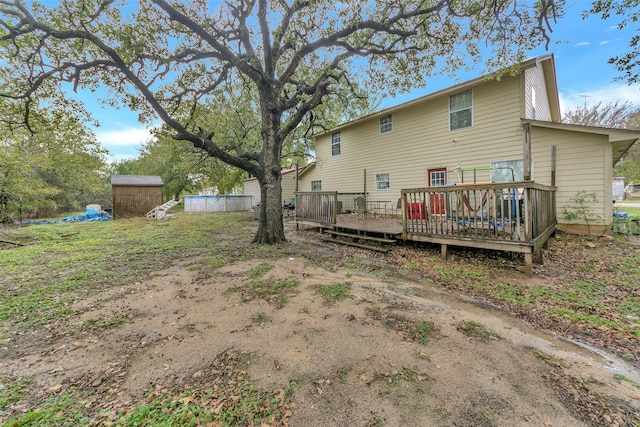 rear view of house with a deck and a storage shed