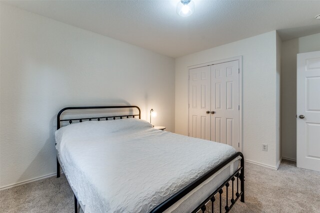 bedroom with light carpet and a closet