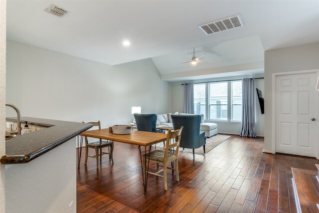 dining space with ceiling fan, dark hardwood / wood-style floors, sink, and lofted ceiling