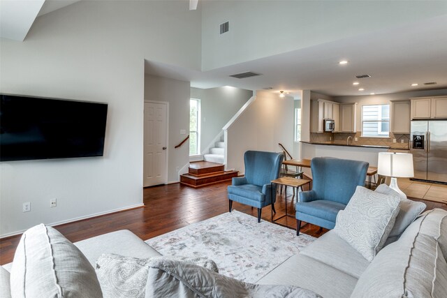 living room featuring hardwood / wood-style floors and a towering ceiling