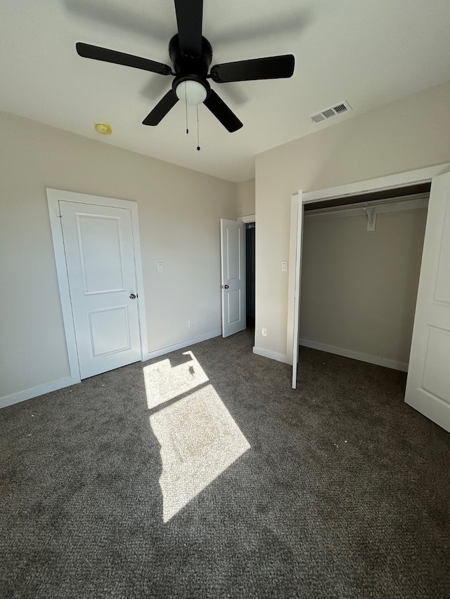 unfurnished bedroom with ceiling fan, a closet, and dark carpet