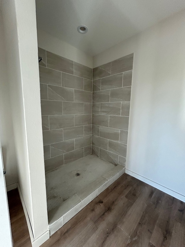 bathroom featuring hardwood / wood-style floors and a tile shower