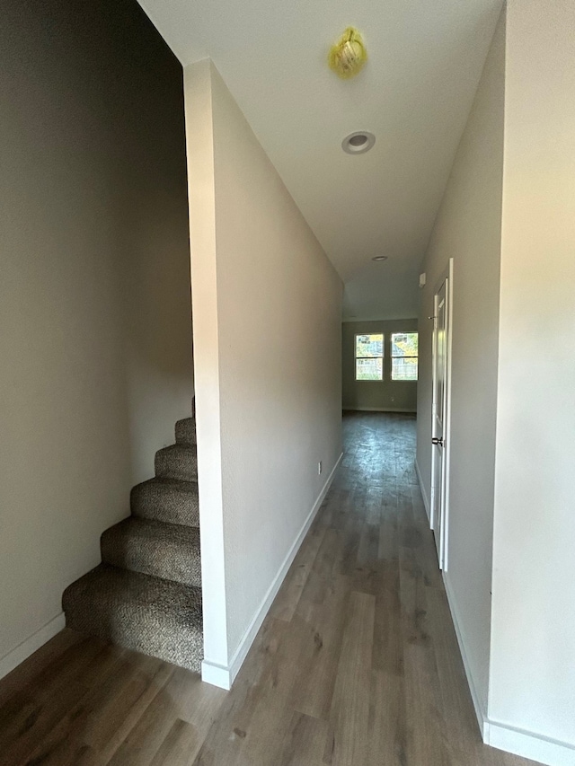 hall with wood-type flooring and lofted ceiling