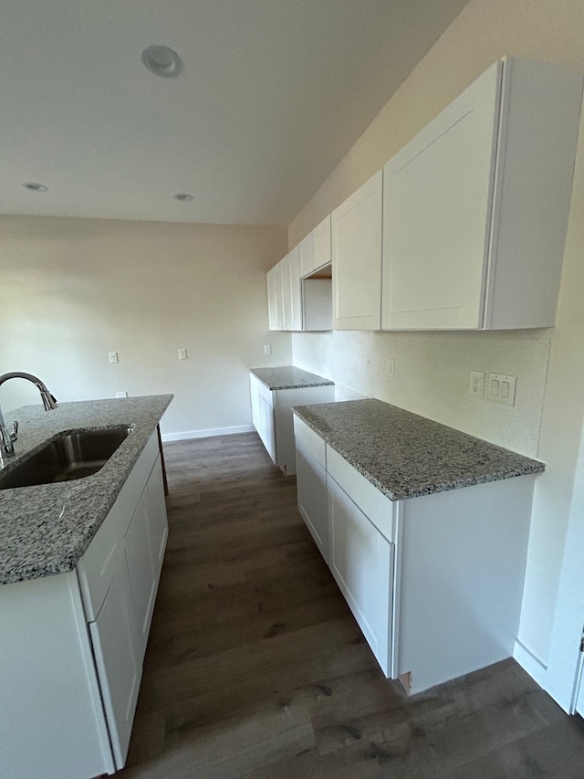 kitchen with white cabinets, sink, and stone counters