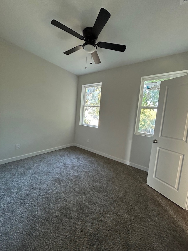 empty room featuring dark colored carpet and ceiling fan