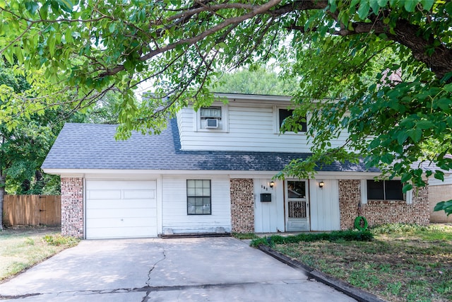 view of front of house with a garage and cooling unit