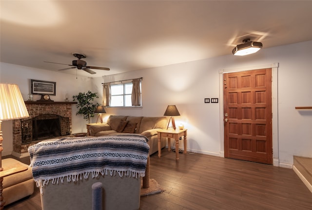 living room featuring a fireplace, dark wood-type flooring, and ceiling fan