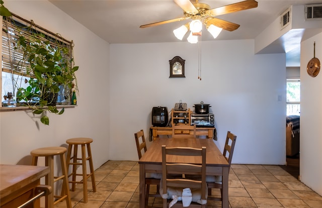 tiled dining space with ceiling fan