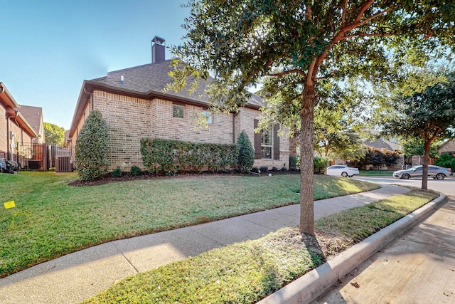 view of side of home featuring central AC and a lawn