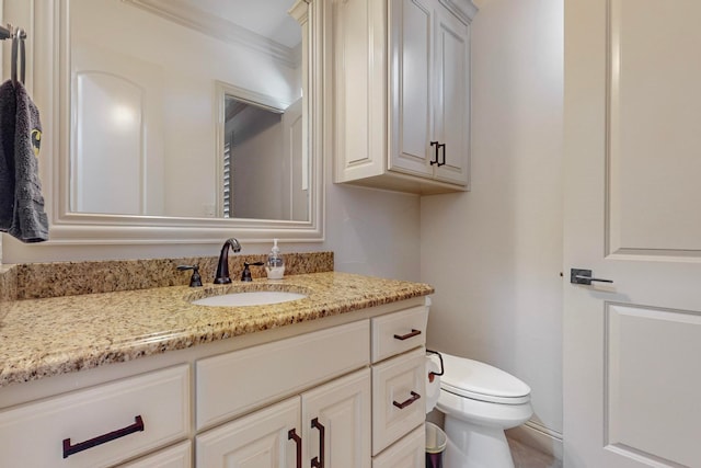 bathroom featuring vanity, toilet, and ornamental molding