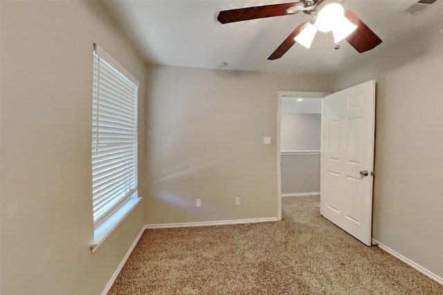 carpeted spare room featuring ceiling fan