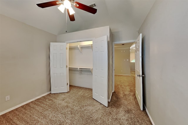 unfurnished bedroom with ceiling fan, a closet, vaulted ceiling, and light colored carpet