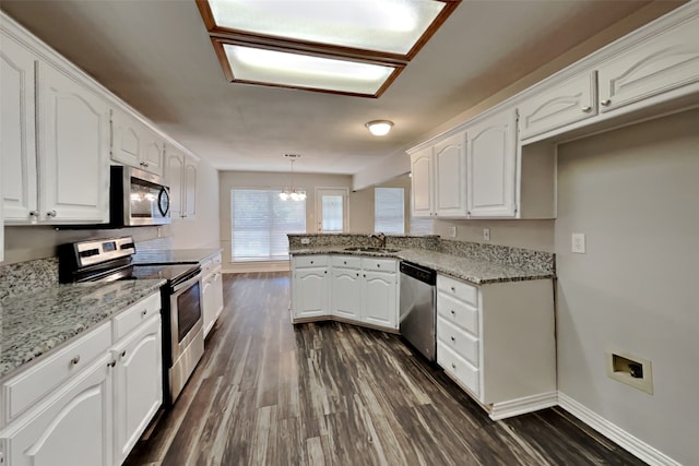 kitchen featuring white cabinetry, hanging light fixtures, sink, and stainless steel appliances