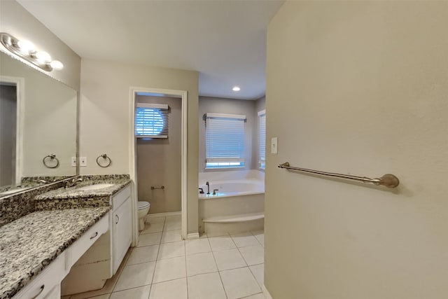 bathroom featuring toilet, vanity, tile patterned flooring, and a bathtub